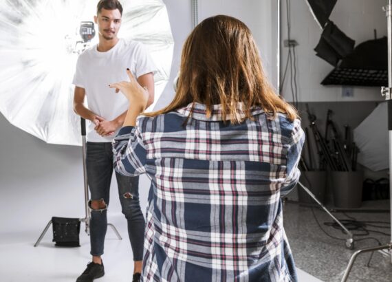 Photographer directing model in a studio